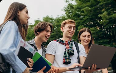 Students working together on a laptop outdoors